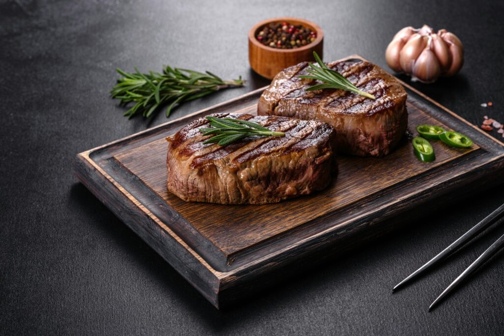 Fresh juicy delicious beef steak on a dark background
